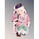 A ceramic tobacco jar in the form of a gentleman in an armchair,