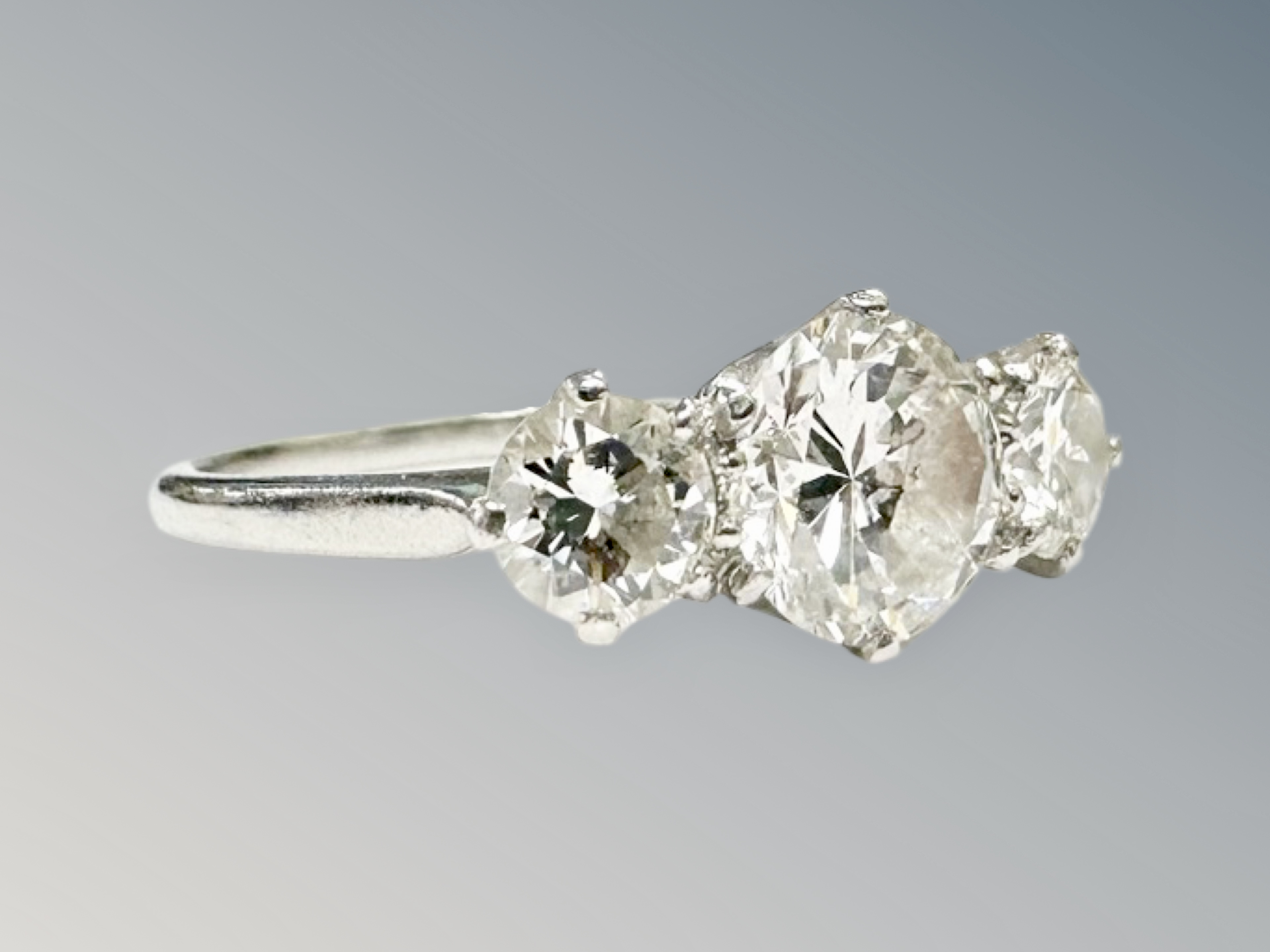 A platinum three stone diamond ring, the principal stone weighing 1. - Image 2 of 3