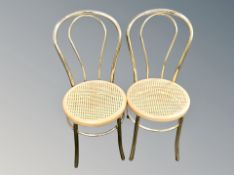 A pair of brass finished cane seated side chairs