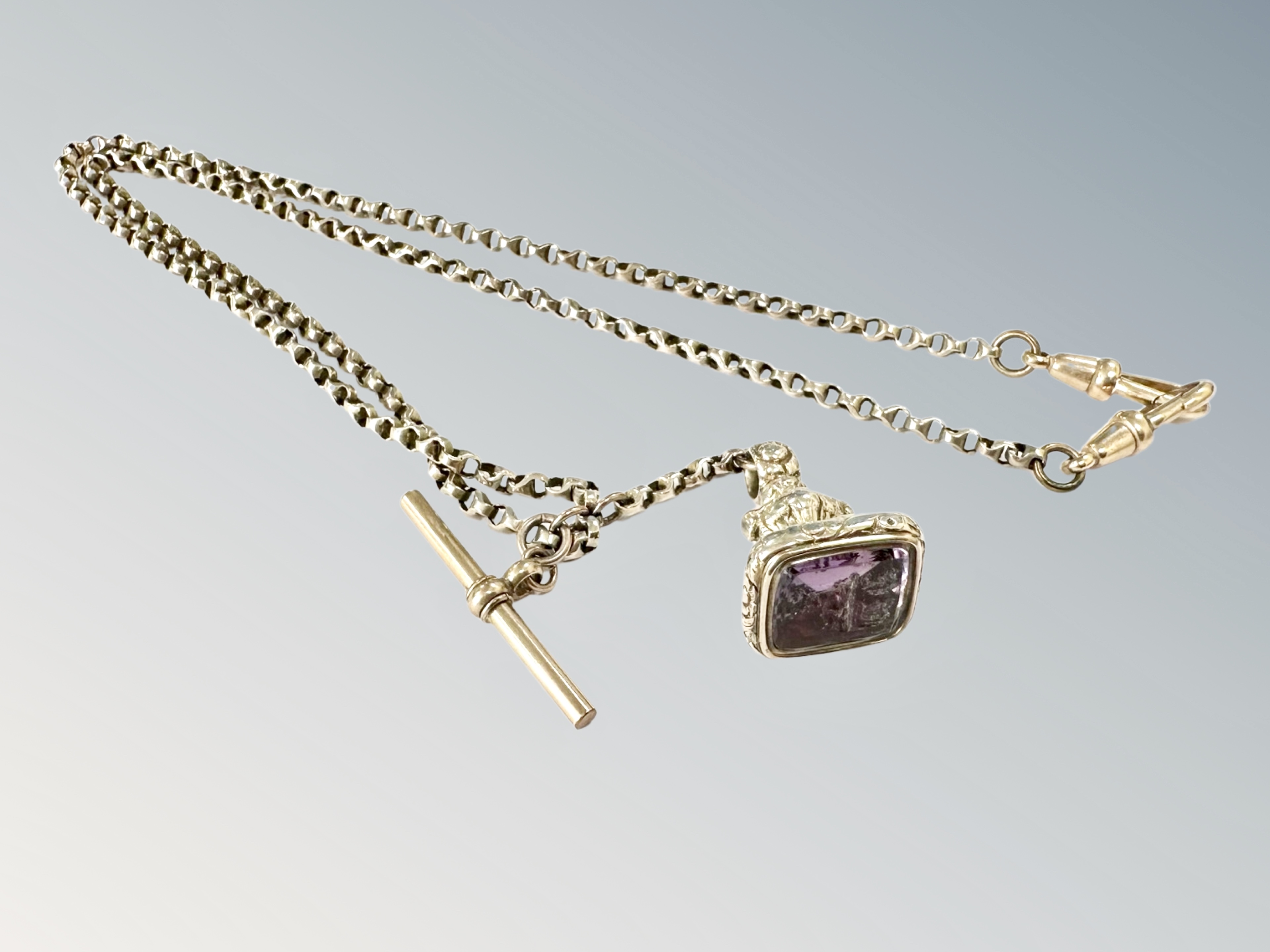 A gold plated watch Albert chain with carved intaglio amethyst-coloured seal
