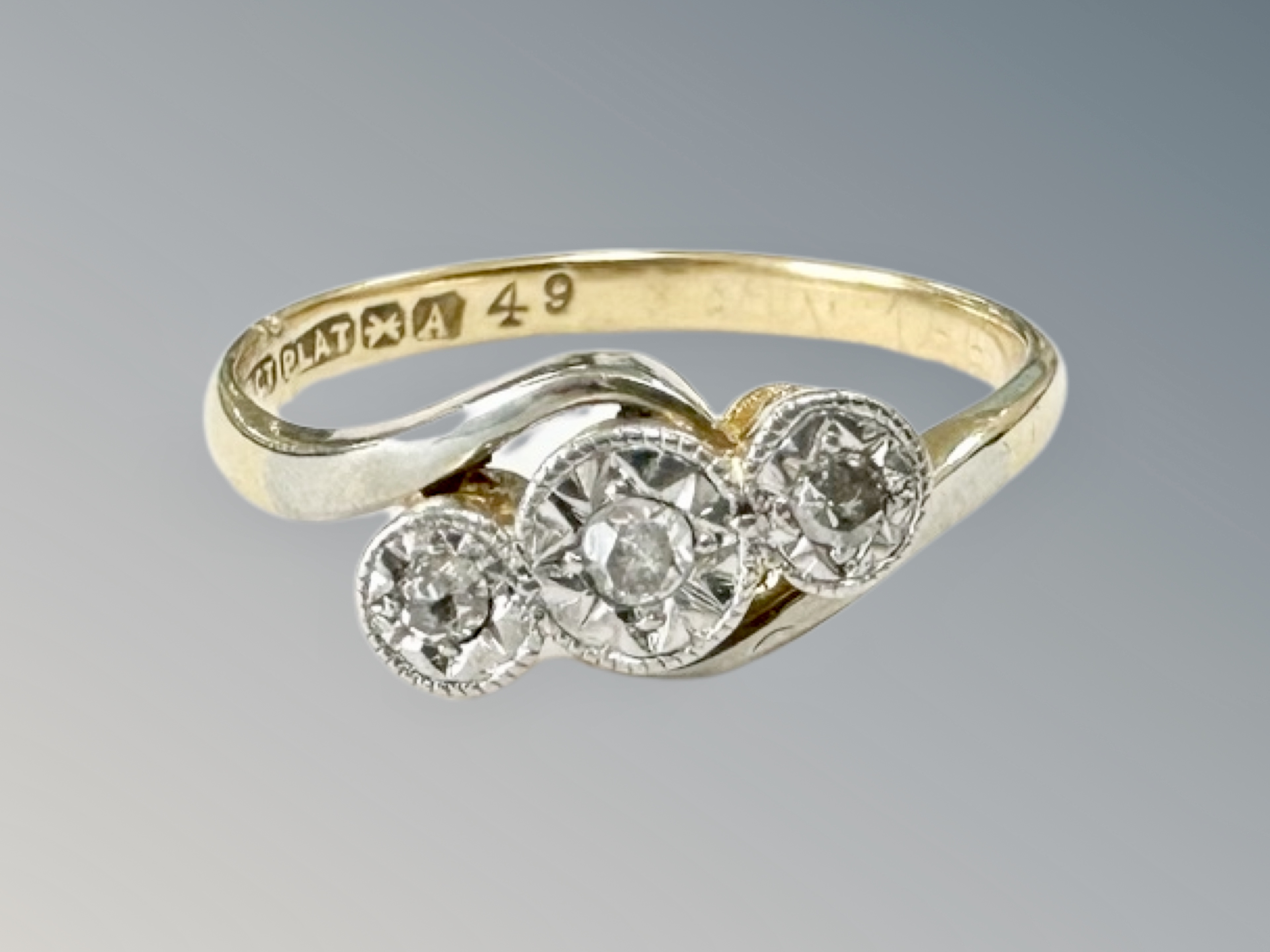 An 18ct gold and platinum three stone diamond ring, size K. CONDITION REPORT: 2.