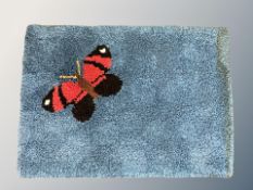 A 1960's wool rug depicting a butterfly 193 cm x 66 cm