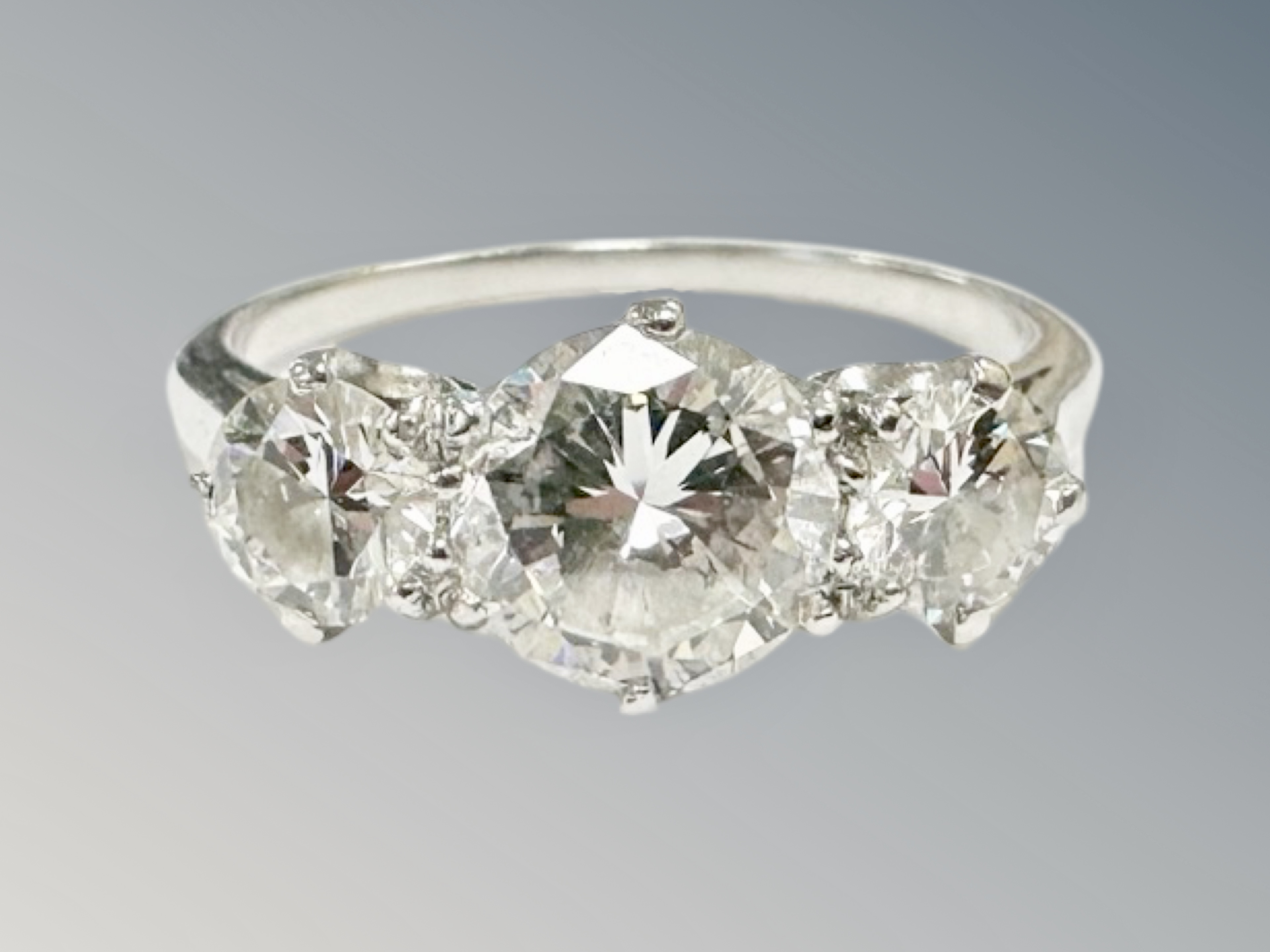 A platinum three stone diamond ring, the principal stone weighing 1.