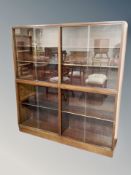 A two section teak sliding glass door bookcase,