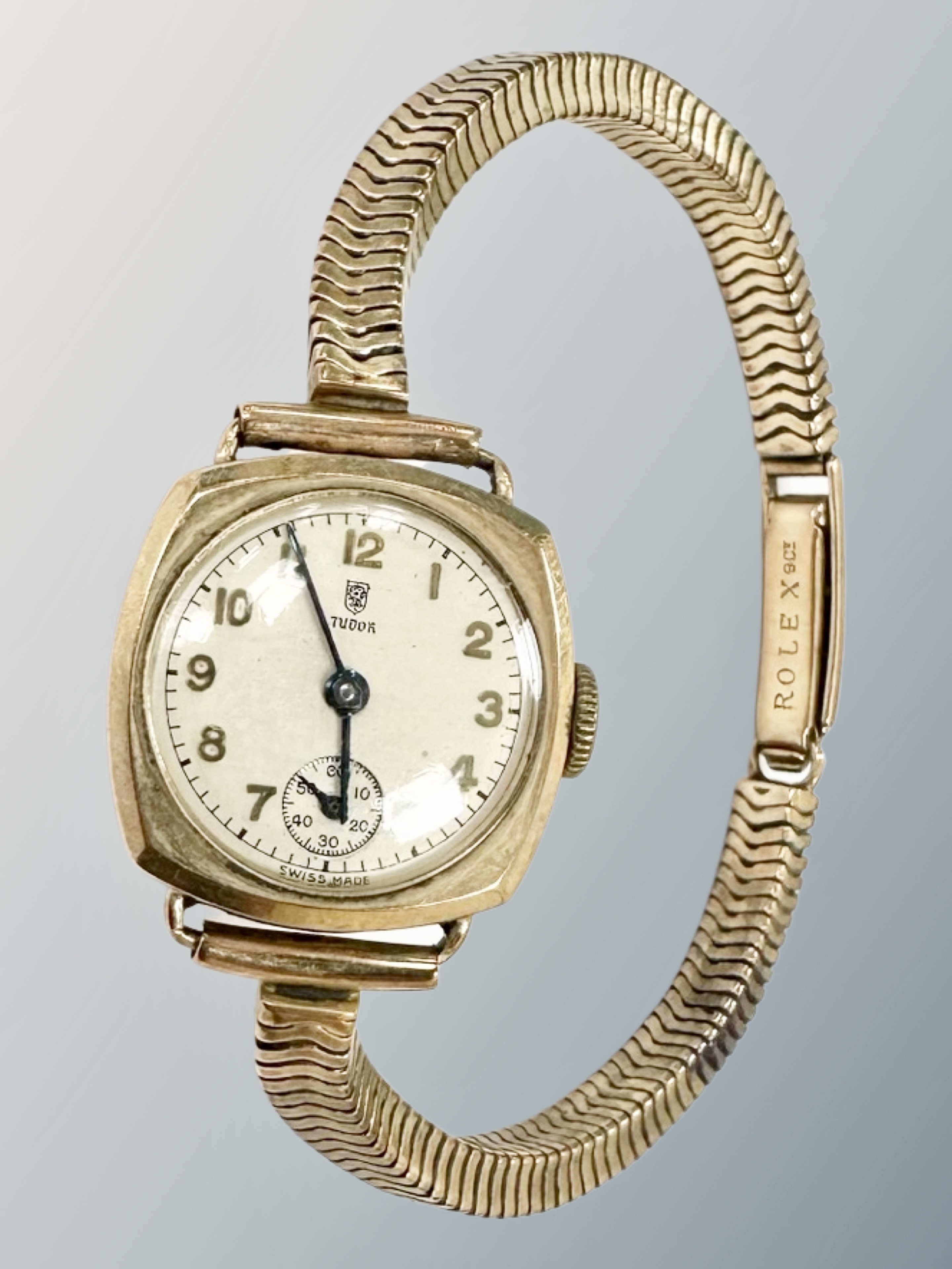 A lady's 9ct gold Tudor wristwatch upon a 9ct gold Rolex articulated strap,