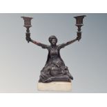 A bronze figural two-branch candelabrum on plinth,