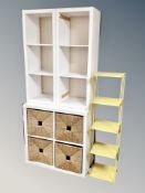 A pair of white cube shelves together with a white cube four drawer shelf and metal four tier stand