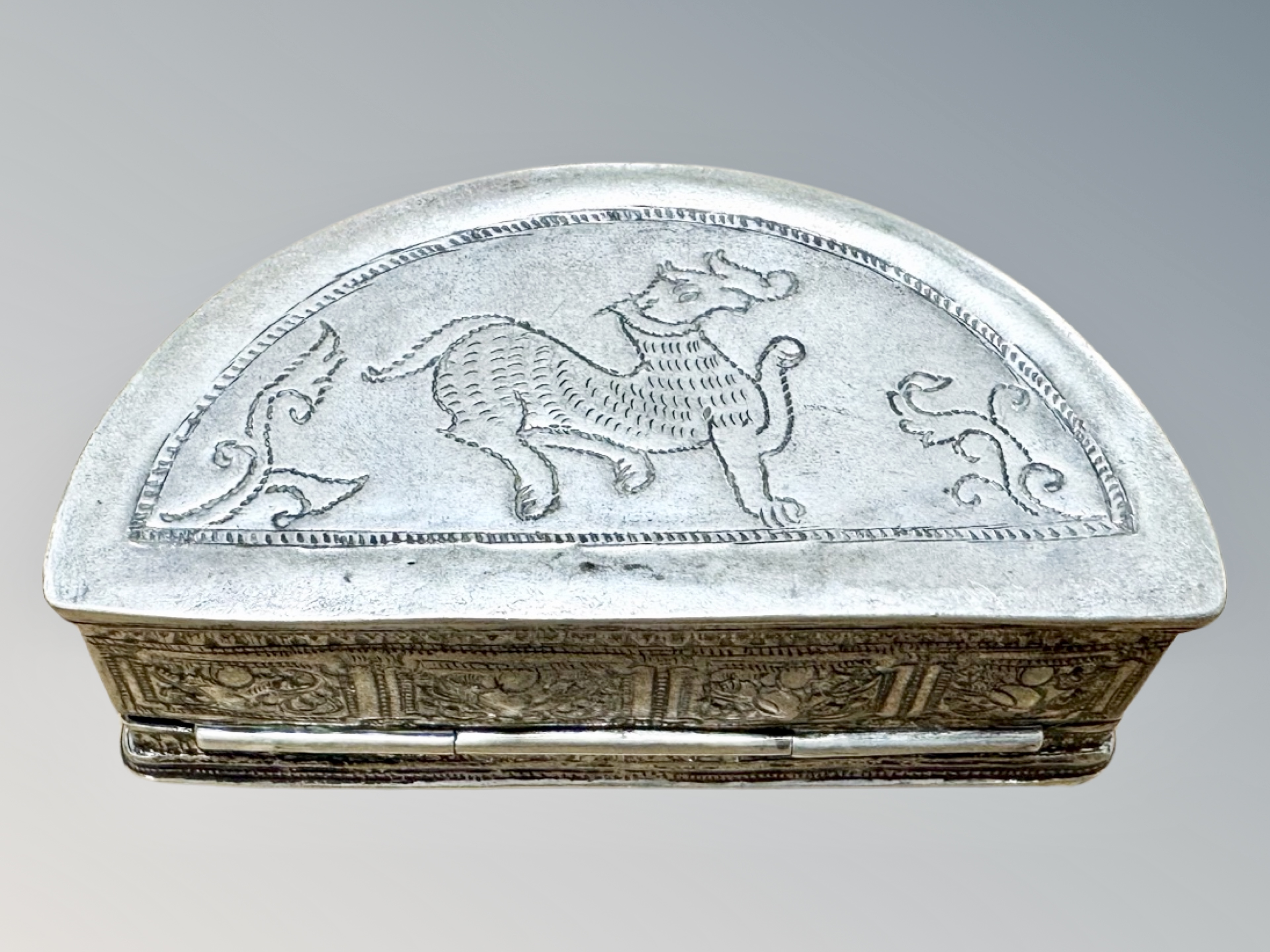 An Indian white metal demi-lune trinket box with all-over embossed decoration, width 9. - Image 2 of 2