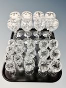 A set of eight cut glass wine glasses and sixteen further smaller glasses