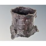 A patternated metal pot decorated with classical figures,