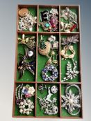 A tray of over twenty five vintage and later costume brooches, inc.