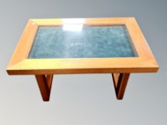 A teak display table with glass top,