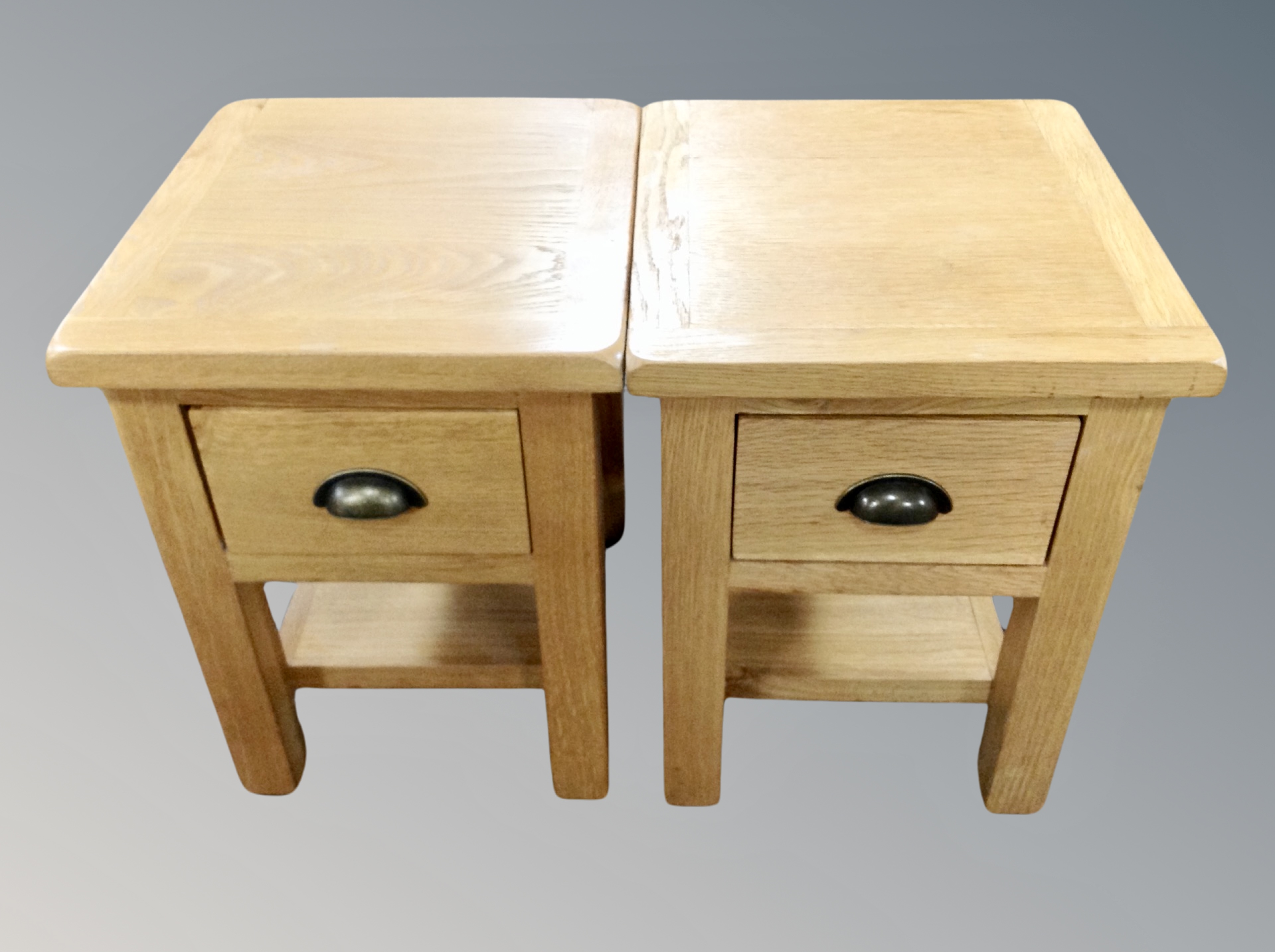 A pair of contemporary oak lamp tables fitted drawers