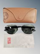 A pair of Rayban sunglasses in case with cleaning cloth