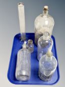 Five vintage glass chemist's bottles together with a further glass measure