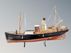 A wooden model of a trawler on stand