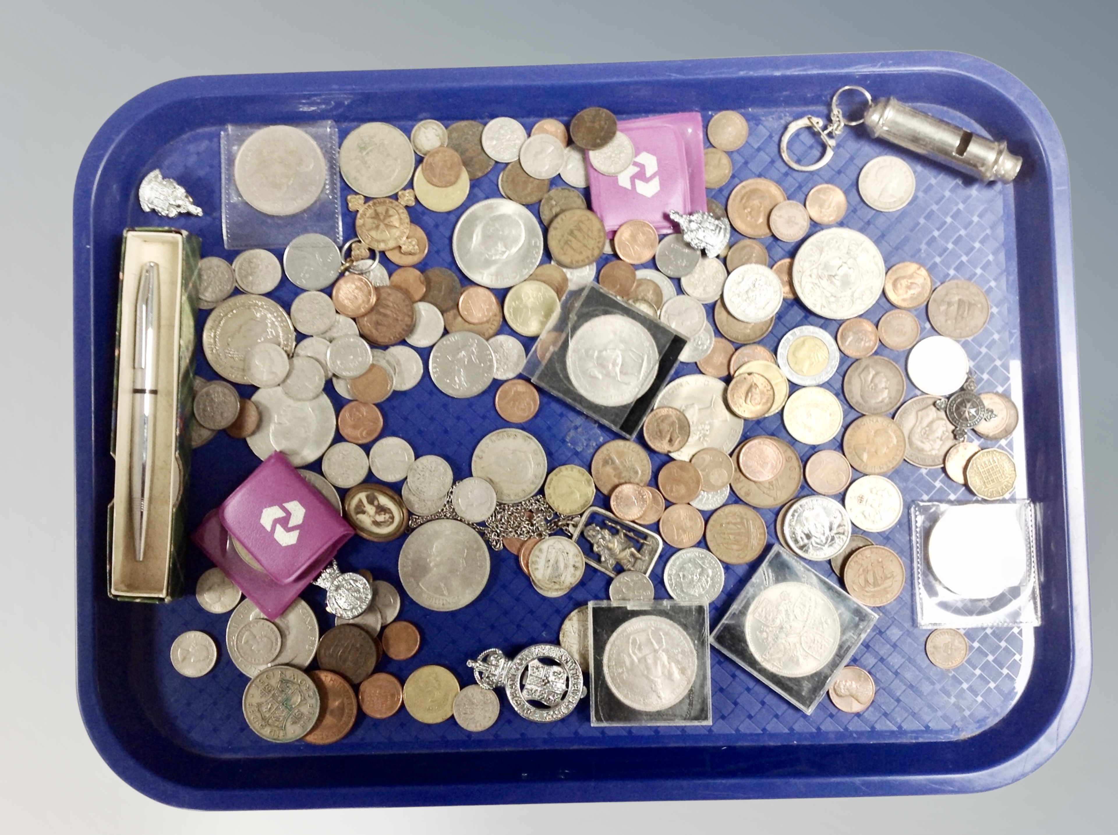 A tray of coins, badges,