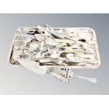 A plated tray of cutlery, cake slice, servers, silver handled server,