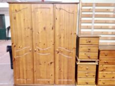 A seven piece contemporary pine bedroom suite comprising of triple door wardrobe, five drawer chest,
