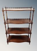 A Victorian style serpentine four tier what-not stand