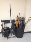 A plastic bin containing assorted garden tools, measuring stick, drain rods,