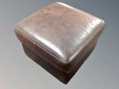 A brown leather square footstool