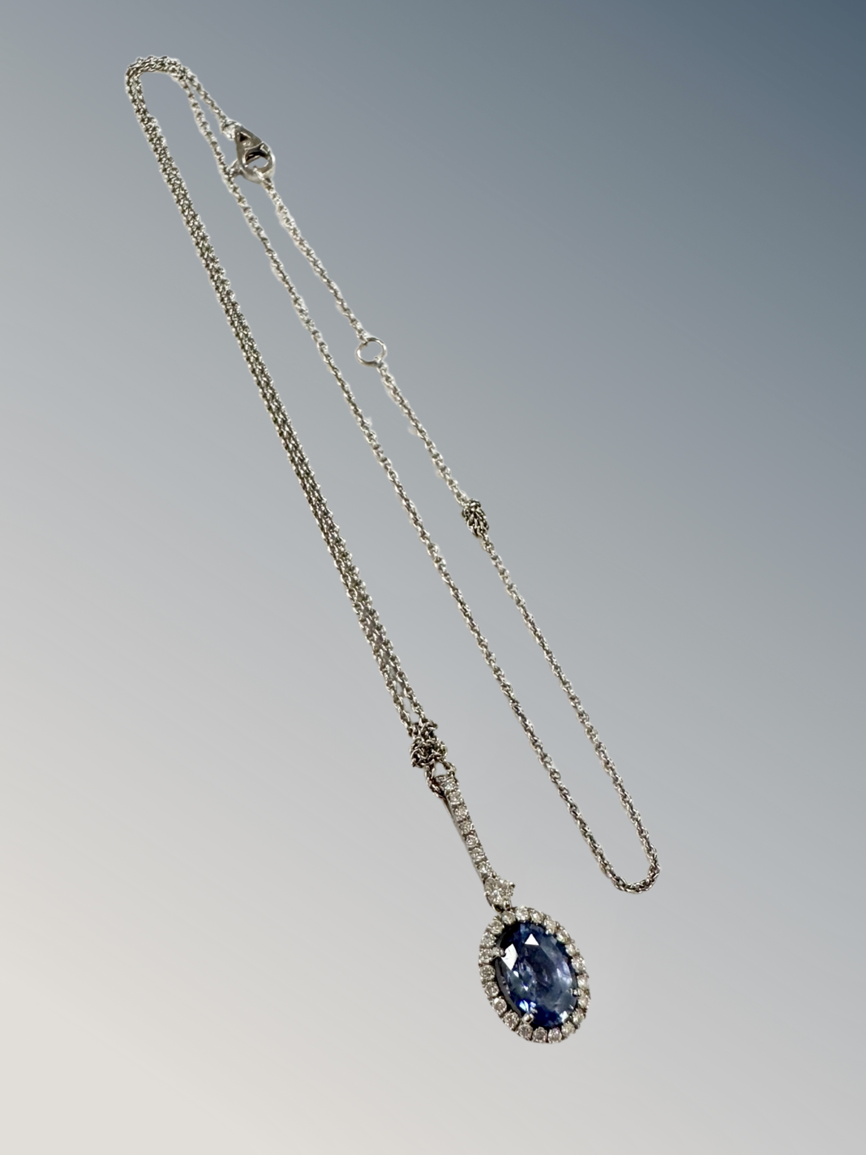 A platinum sapphire and diamond cluster pendant suspended on white metal chain CONDITION