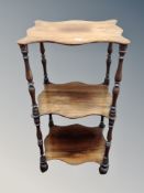 An early Victorian rosewood three tier what-not stand on brass castors