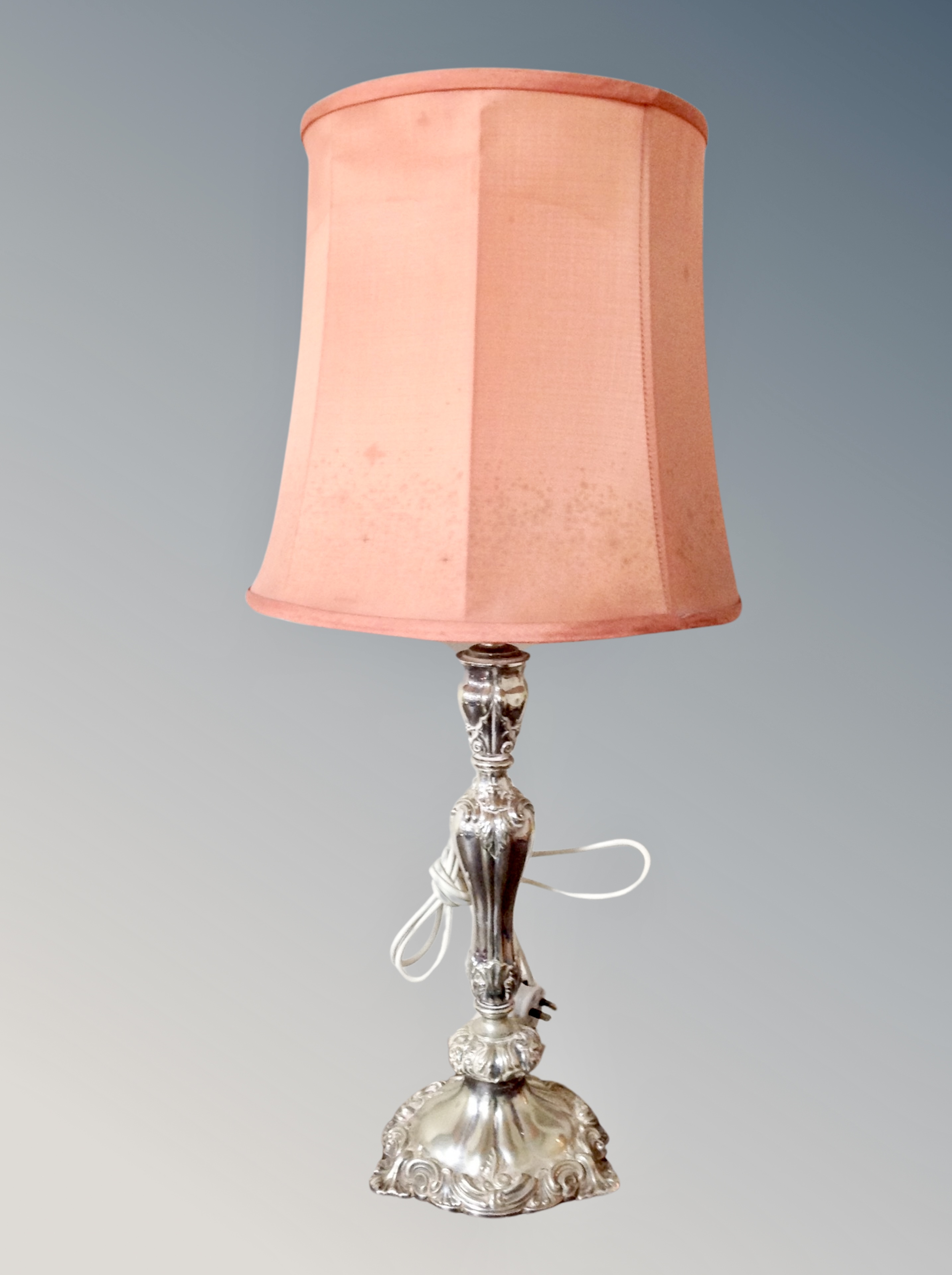 An ornate silver plated table lamp with shade,
