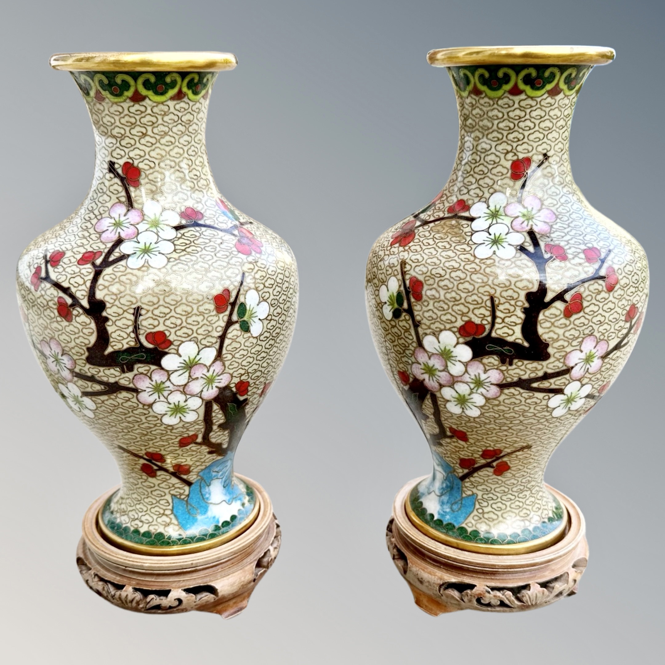 A pair of Japanese cloisonné vases on wooden stands,