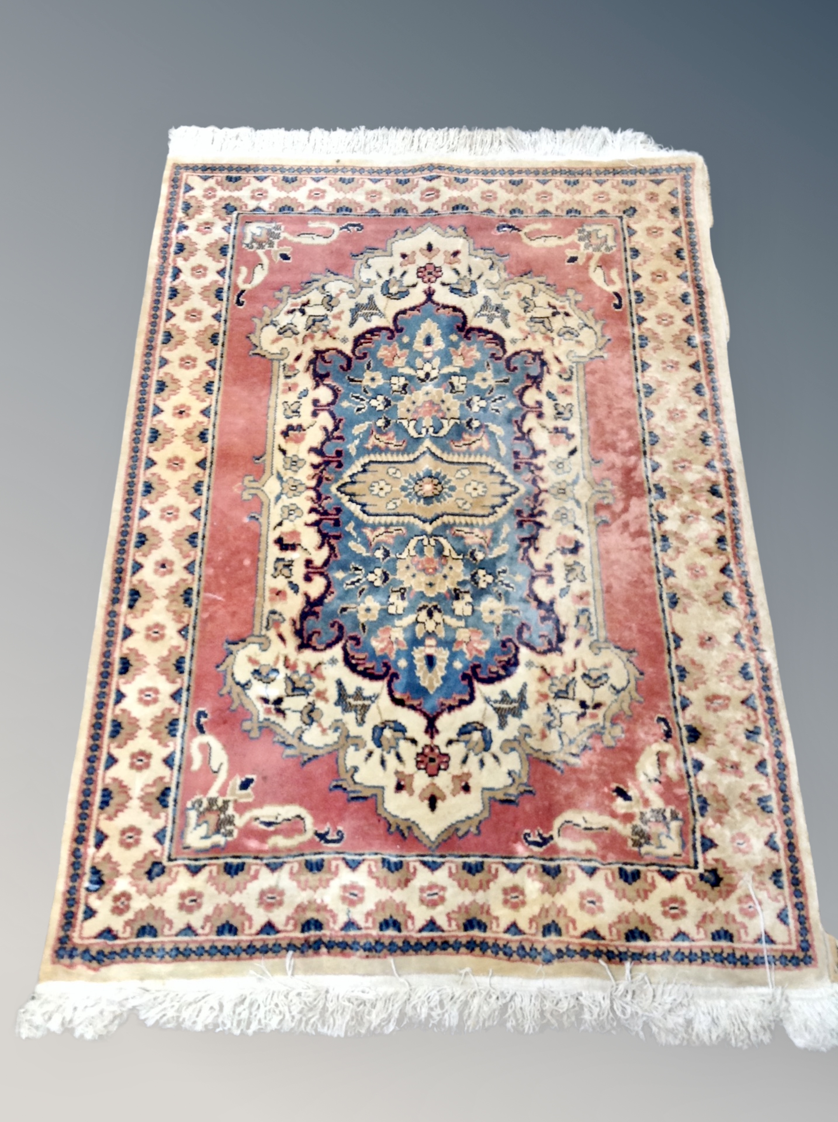 A fringed rug of Persian design,