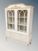 A 20th century Scandinavian cream and gilt double door display cabinet fitted with four drawers