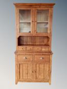 An Irish Cabinet Collection glazed pine kitchen cabinet fitted with cupboards and drawers