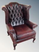 An oxblood Chesterfield wingback armchair
