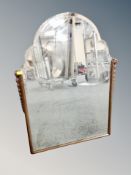 An Edwardian oak framed shaped bevelled mirror, 57cm wide by 77cm high.