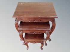 A nest of three carved tables