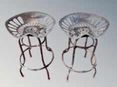 A pair of contemporary tractor seat bar stools