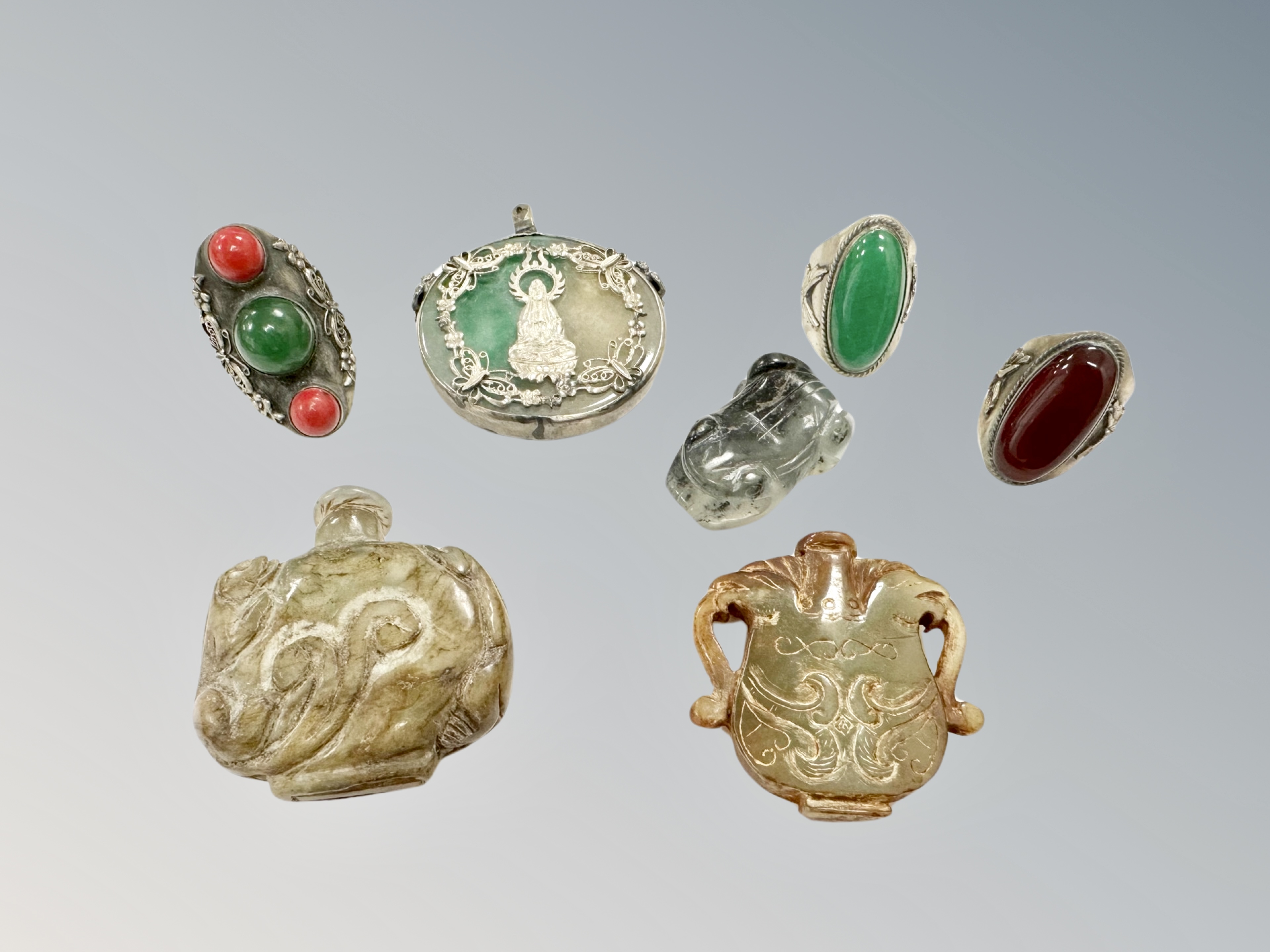 A Chinese jade and white metal circular disk pendant, three hard stone inset rings,