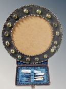 An Arts & Crafts circular picture frame, set green glass cabochons,