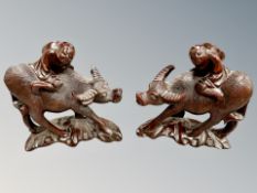 A pair of Chinese hardwood carvings of figures astride water buffaloes, height 17.