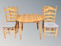 A circular pine extending kitchen table together with four ladder backed pine chairs and further