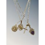 A 9ct gold chain holding a crucifix pendant and a further heart-shaped amethyst and seed pearl