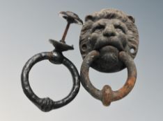An antique cast iron door knocker modelled as a lion's head and another plain ring