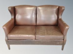 A Danish brown leather two seater wing backed settee with armchair