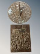 A bronze wall plaque and a sun dial