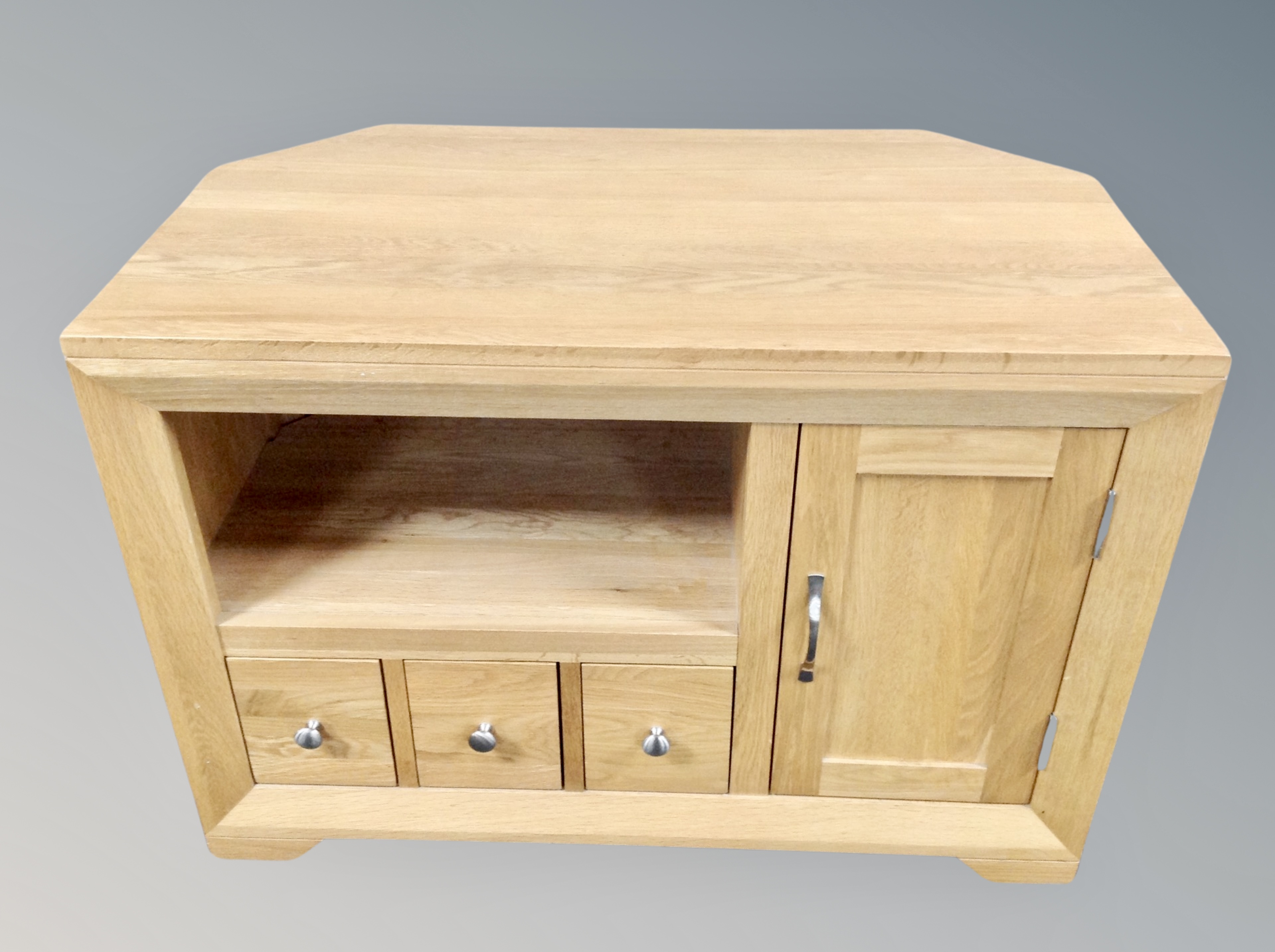 A contemporary oak TV stand fitted cupboards and drawers