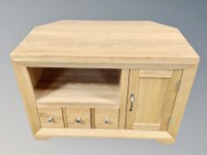 A contemporary oak TV stand fitted cupboards and drawers