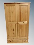 A three piece contemporary pine bedroom suite comprising of double door wardrobe,