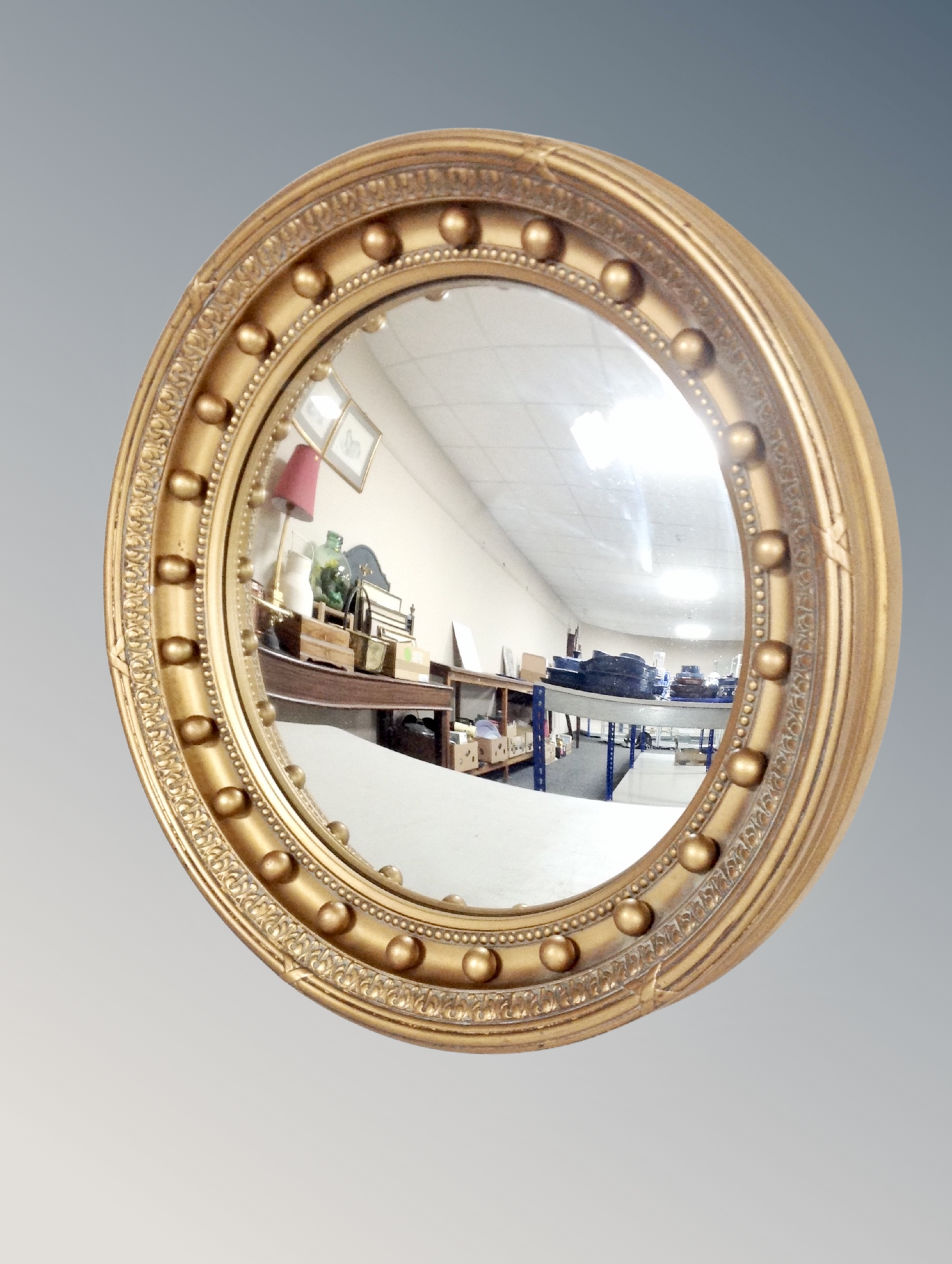 A gilt composite beaded framed porthole mirror