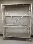 An aluminium four tier trolley / shelf on castors,